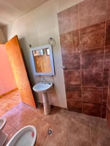 La salle de bains est pourvue d'un lavabo, de toilettes et d'un miroir. dans l'établissement AMA WARA, à Maimará