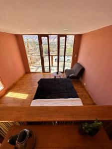 Bett in einem Zimmer mit einem großen Fenster in der Unterkunft AMA WARA in Maimará