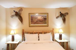 a bedroom with a bed with two birds on the wall at Trapper 8 in West Yellowstone