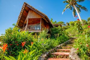 ein Haus mit einer Treppe, die zu einem Garten führt in der Unterkunft Palau Carolines Resort in Koror