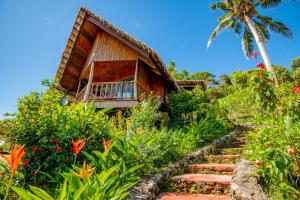 a house with a staircase leading up to a garden at Palau Carolines Resort in Koror