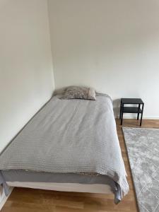 a bed with a gray comforter in a bedroom at Cozy Rooms between Airport&Center in Stockholm