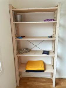 a book shelf with a yellow pillow on it at Cozy Rooms between Airport&Center in Stockholm