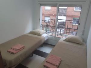 2 Betten in einem Zimmer mit Fenster in der Unterkunft Lucky House in Badalona