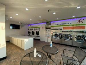 a laundry room with two tables and washing machines at Soldongsan Stay in Seogwipo