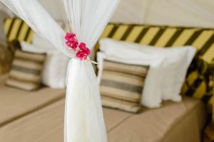 a white curtain with pink flowers on top of it at Montebelo Gorongosa Lodge & Safari in Chitengo