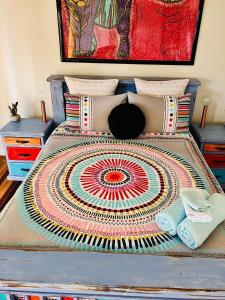 a bed with a colorful comforter on top of it at Timbertop for Life in Gold Coast