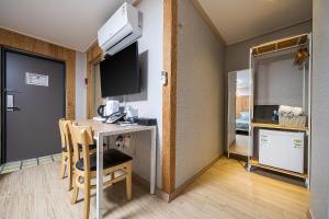a hotel room with a desk and a tv and a room at Hotel Hue in Tongyeong