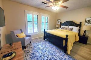 a bedroom with a bed and a chair and a ceiling fan at Hidden Gem 3bd/2bth 1levl in Hot Springs Village