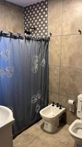 y baño con cortina de ducha y lavamanos. en Hermosa casa en Cafayate en Cafayate