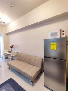 a living room with a couch and a refrigerator at Coast Residences, Roxas Blvd, Pasay City in Manila