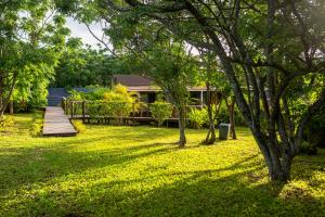 a yard with a wooden walkway and a house at Cabañas Raupa in Hanga Roa