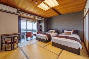 a hotel room with two beds and a balcony at Sado Resort Hotel Azuma in Sado