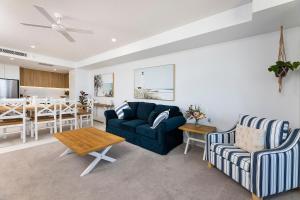 a living room with a couch and chairs and a table at Solaris 606 in Forster