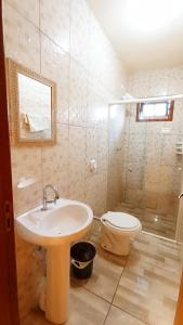 La salle de bains est pourvue d'un lavabo et de toilettes. dans l'établissement Casa Colonial em Guaratuba, próximo a praia, à Guaratuba