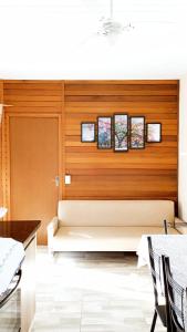 Sofá blanco en una habitación con pared de madera en Casa Colonial em Guaratuba, próximo a praia en Guaratuba