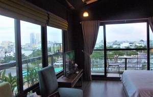 a hotel room with a bed and a large window at Oasis Hotel & Apartment in Da Nang