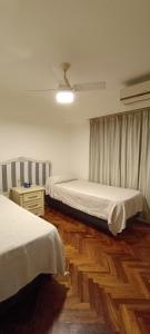 1 dormitorio con 2 camas y suelo de madera en Semipiso 3 Dormitorios 2 Baños Nueva Córdoba en Córdoba
