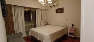 um quarto com uma cama, uma cadeira e uma janela em Semipiso 3 Dormitorios 2 Baños Nueva Córdoba em Córdova