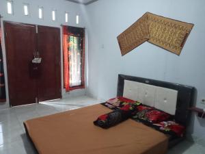 ein Schlafzimmer mit einem Bett in einem Zimmer in der Unterkunft Roby Homestay in Kuta Lombok