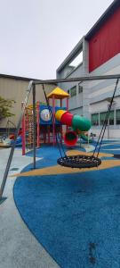 um parque infantil com escorrega e um baloiço em peace home cyberjaya em Cyberjaya