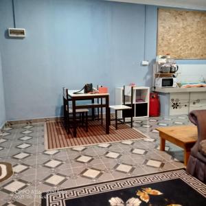 ein Wohnzimmer mit einem Tisch und einer Küche in der Unterkunft Homestay Kenangan Kemaman in Cukai