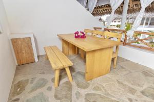un tavolo e sedie in legno in una stanza di Cacuki Boutique House a Watamu