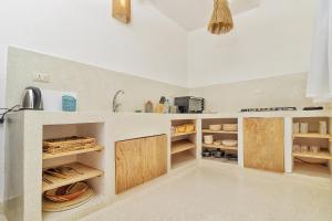 a kitchen with wooden cabinets and a sink at Cacuki Boutique House in Watamu