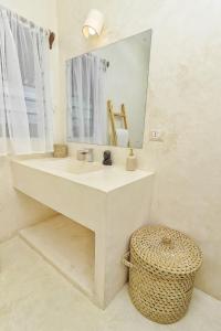 a bathroom with a sink and a mirror and a stool at Cacuki Boutique House in Watamu