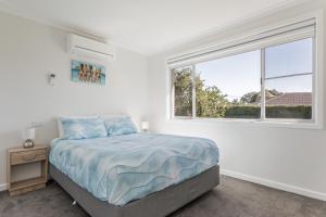 ein weißes Schlafzimmer mit einem Bett und einem Fenster in der Unterkunft Fisherman's Rest in Emu Point