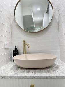 baño con lavabo blanco grande y espejo en Hillhaven Holiday Apartments, en Gold Coast