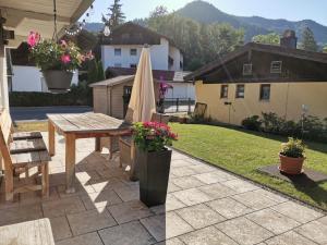 um pátio com um guarda-sol, uma mesa e cadeiras em Ferienwohnung Sturm em Ruhpolding