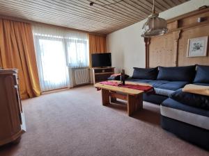 uma sala de estar com um sofá azul e uma mesa de centro em Ferienwohnung Sturm em Ruhpolding