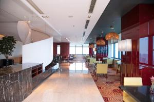 a lobby of a hotel with tables and chairs at Renaissance Shanghai Zhongshan Park Hotel in Shanghai