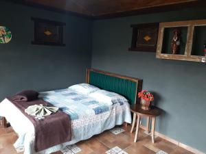 Ένα ή περισσότερα κρεβάτια σε δωμάτιο στο Chalé Pakere Montebello Lumiar - lareira, wi-fi, sauna, piscina - vista incrível - locação do chalé sem prestação de serviços +86 φωτογραφίες