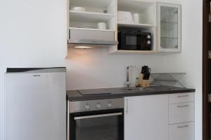 a kitchen with a stove and a microwave at 1Br Poolside Apartment, Long Beach, Lanta Sport Resort 109 in Ko Lanta