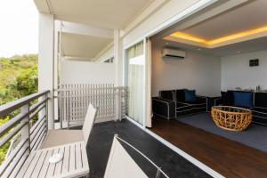 a balcony with a couch and a table at Mantra Samui Resort - Adults Only in Mae Nam