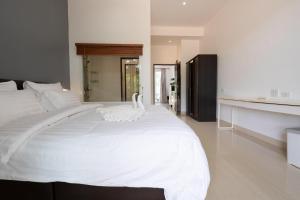 two white swans sitting on top of a white bed at 1Br Poolside Apartment, Long Beach, Lanta Sport Resort 109 in Ko Lanta +10 photos