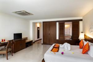 a hotel room with a bed and a desk and a television at Patong Paragon Resort & Spa SHA Extra Plus in Patong Beach