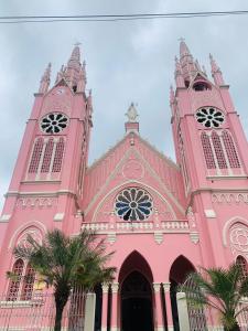 una iglesia rosa con dos torres y una palmera en Aloja-T en Casa amoblada en Jericó, en Jericó