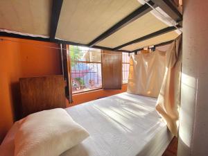 a bedroom with a white bed with a window at Alena Hostal in Valladolid