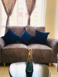 un sofá con almohadas azules y una botella en una mesa en Apartamento Madrid cund, en Madrid