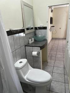 a bathroom with a white toilet and a sink at Chalchuapa, Santa Ana La Casa de Sussy, El Salvador in Chalchuapa