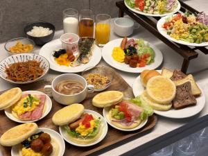 una mesa con muchos platos de comida. en S-peria Inn Nihombashi Hakozaki, en Tokio