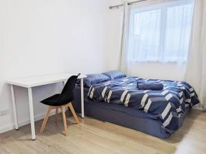 a bedroom with a bed and a desk and a chair at PROMO! Entire 2 Bedroom Unit Near Train Station! Free Parking & Wifi! in Melbourne
