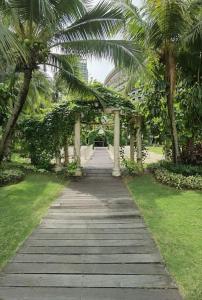 uma passarela com palmeiras num parque em Carnelian Tower - Balcony & Sunset View 4204 em Gelang Patah