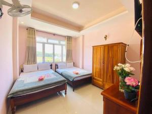 a bedroom with two beds and a window at Khách sạn Quang Vinh in Da Lat