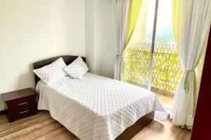 1 dormitorio con cama y ventana grande en Av santander Apartaestudio premium, en Manizales