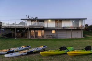 a group of kayaks parked in front of a house at 690 Pukehina - Whare Nui in Pukehina