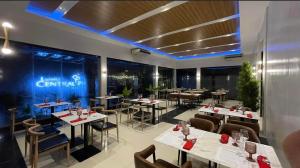 a restaurant with tables and chairs in a room at Luisita Central Park Hotel in Tarlac